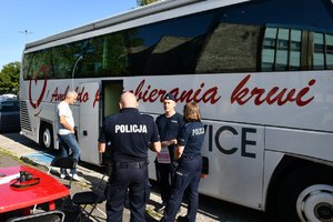 Policjanci stoją przez ambulansem Regionalnego Centrum Krwiodawstwa i Krwiolecznictwa z Katowic