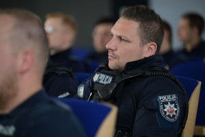 na zdjęciu policjant, na ramieniu emblemat policja instruktor