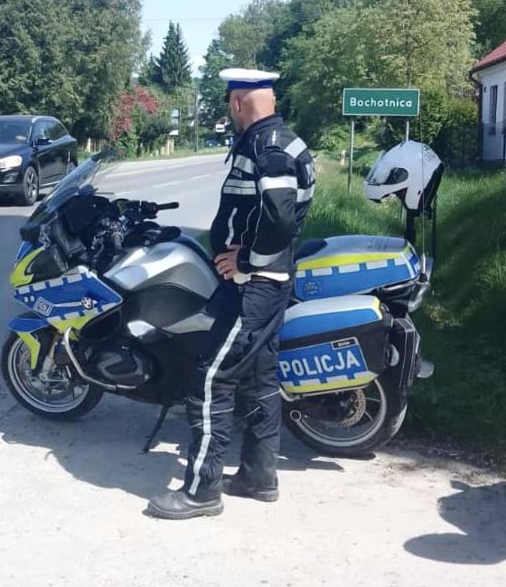 policjant przy ulicy stoi obok motocykla