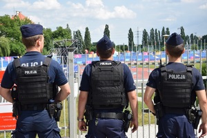 trzech umundurowanych policjantów obserwujących obiekt spotrowy krakowskiej Akademii Wychowania Fizycznego
