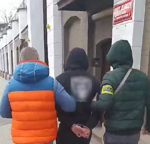 dwóch nieumundurowanych policjantów prowadzi zatrzymanego do aresztu śledczego