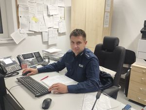 Policjant siedzący za biurkiem