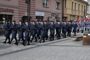 Zdjęcie. Widoczny przemarsz policjantów i uczestników uroczystości ulicami miasta