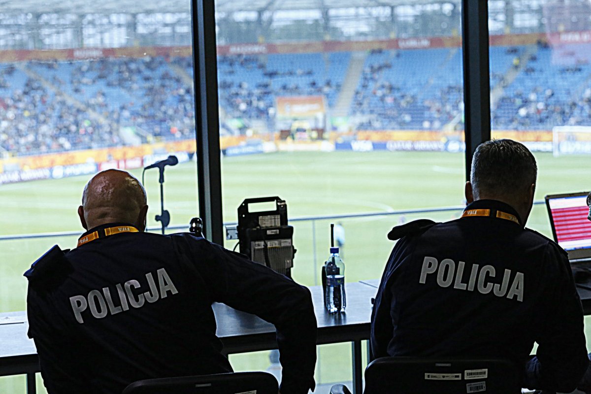 Policjanci obserwują stadion w czasie meczu.