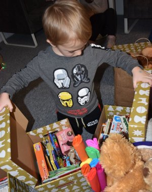 chłopczyk otwierający pudła z prezentami