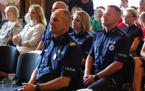 Na pierwszym planie siedzi komendant wojewódzki opolskiej policji, w tle policjanci z KWP w Opolu i goście gali