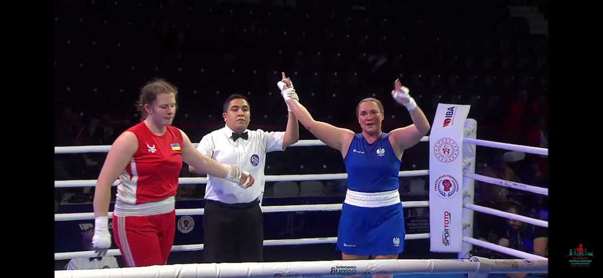 dwie kobiety na ringu, sędzia podnosi rękę w górę jednej z nich ogłaszając zwyciężczyznię