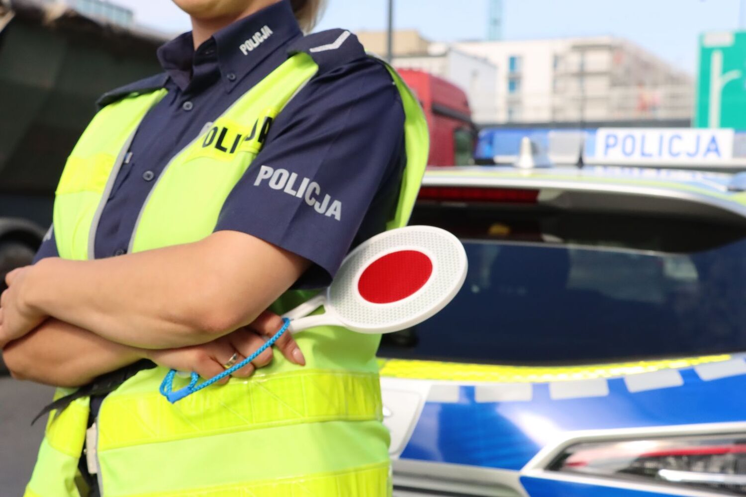 Policjantka ruchu drogowego trzyma w ręku policyjnego "lizaka".