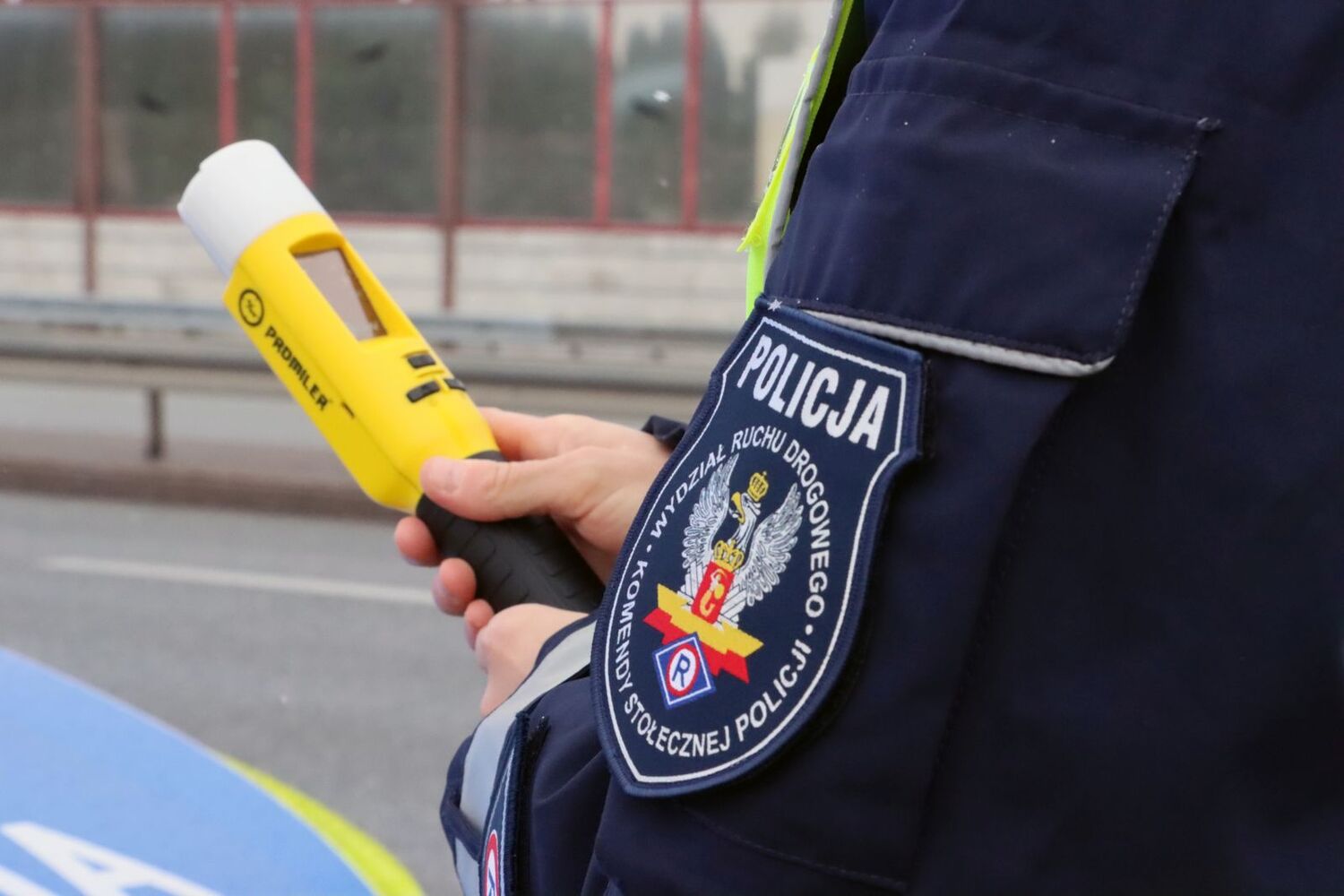 Policjant trzyma w ręku alkotest.