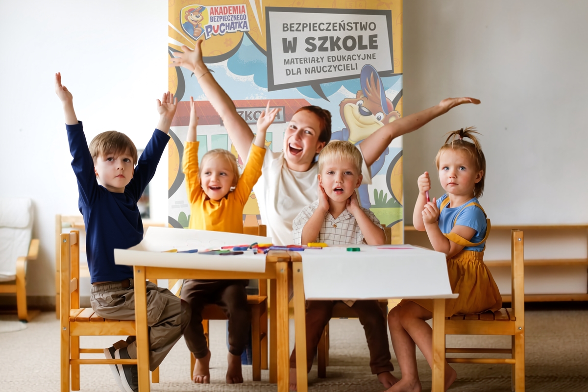 Kobieta z grupą dzieci siedzącą na krzesłach przy stolikach. na stolikach kartki papieru oraz przybory do rysowania - kredki, mazaki.