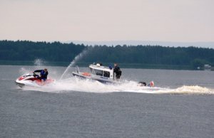 policjanci na łódce ścigają skuter wodny