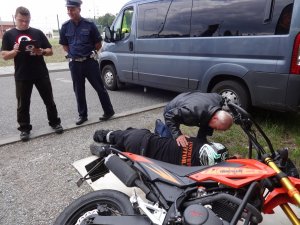 Bezpieczny motocyklista w drodze na wakacje - udzielanie pomocy pozorantowi