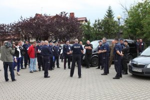 policjanci i zaproszeni goście rozmawiają na parkingu przed szkołą