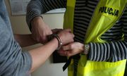 Policjant zakłada zatrzymanemu kajdanki - zdjęcie poglądowe