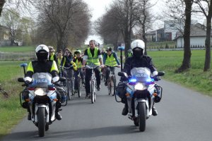 policjanci na motocyklach prowadzą peleton kolarzy