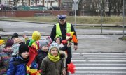 policjant przeprowadza dzieci przez przejście