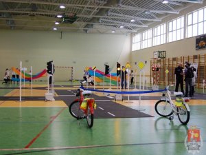 sala gimnastyczna z ustawionymi znakami drogowymi i rowerami