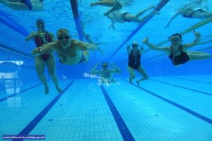 zawodnicy z medalami w basenie - zdjęcie pod wodą