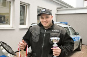 policjant z pucharem i medalem