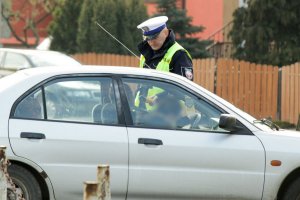 policjat kontrolujący stan trzeźwości kierowcy
