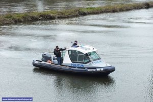 policjanci w łodzi płynący rzeką