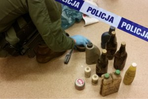 policjant i znalezione pojemniki z niebezpiecznymi substancjami