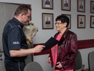 Pani Stefania otrzymuje kwiaty od Policjanta
