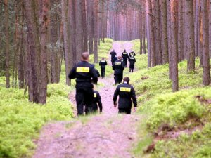 policjanci w moro biegną przez las