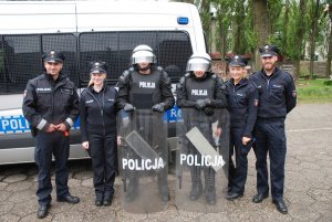 niemieccy policjanci z polskimi policjantami z pododdziałów prewencji na tle radiowozów