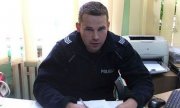 policjant siedzi przy biurku
