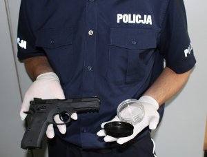policjant trzyma pistolet