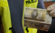 policjant trzyma pieniądze