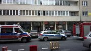 policyjny radiowóz i karetka przed budynkiem