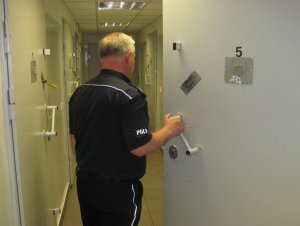 policjant zamyka drzwi celi
