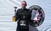 polkowicki policjant z pucharem, medalem i dyplomem
