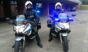 bohaterscy policjanci na motocyklach z włączonymi lampami przodem