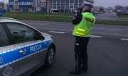 policjant drogówki dokonuje pomiaru przy ulicy