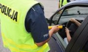 policjant kieruje alkomat w stronę kierowcy siedzącego w aucie