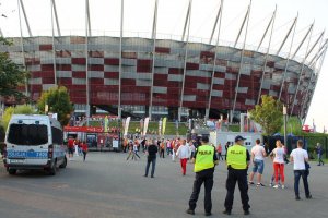 dwaj policjanci stoją przed stadionem narodowym