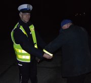 policjant i pieszy z elementami odblaskowymi na kurtce