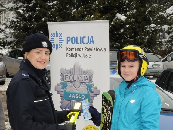 policjantka rozdaje dzieciom materiały informacyjno-edukacyjne akcji &quot;Kręci mnie bezpieczeństwo na stoku&quot;