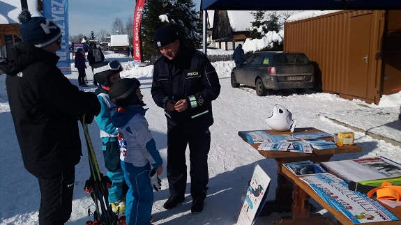 Na stoku narciarskim policjanci rozdają materiały informacyjne