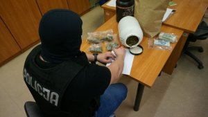 policjant z zabezpieczonymi narkotykami