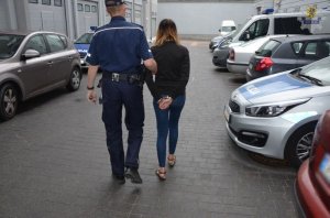 zatrzymana kobieta prowadzona przez policjanta
