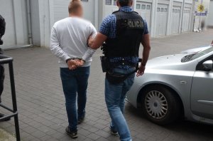 zatrzymany mężczyzna prowadzony przez policjanta