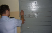 policjant zamyka drzwi policyjnej celi