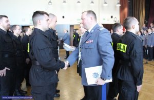 Nadispektor Tomasz Trawiński grtuluje nowo przyjętemu policjantowi