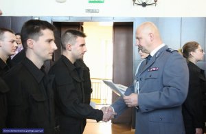 Gratulacje nowo przyjętemu policjantowi składa inspektor Piotr Leciejewski