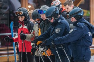 Kręcie mnie bezpieczeństwo na stoku - Kasina - policjanci ustawiają się by usiąść na ławeczce wyciągu