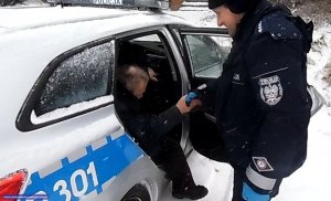 policjant pomaga wysiąść z radiowozu starszemu człowiekowi